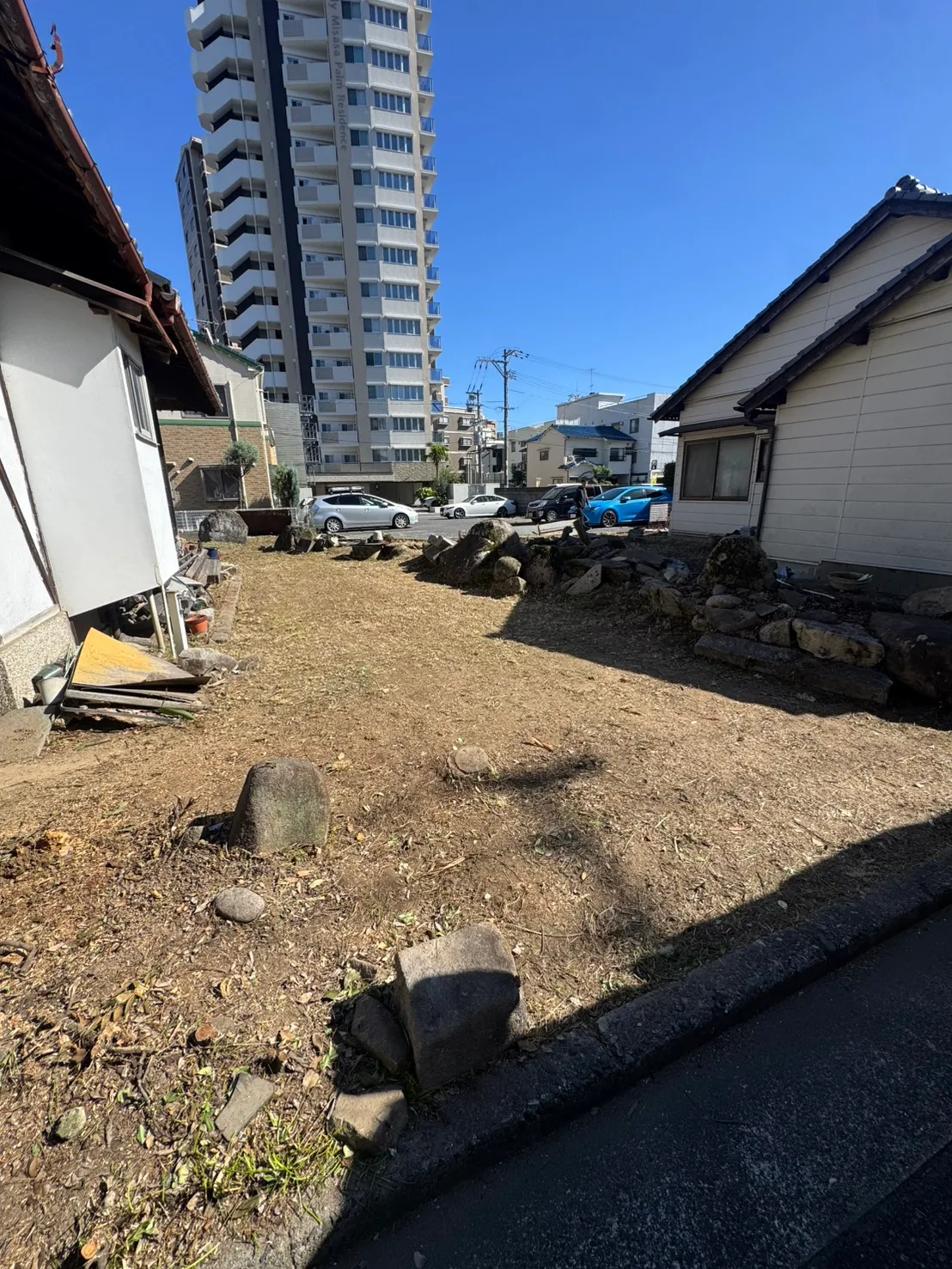 三滝町で庭木の伐採と草刈りを終え、地面と庭石が見えるようになった住宅の庭
