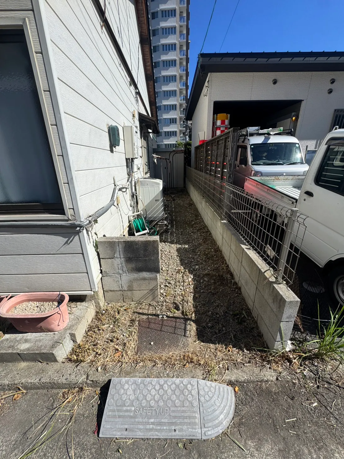 三滝町の施工後。建物と駐車場の間の草木を整理し、地面が見えるようになった様子